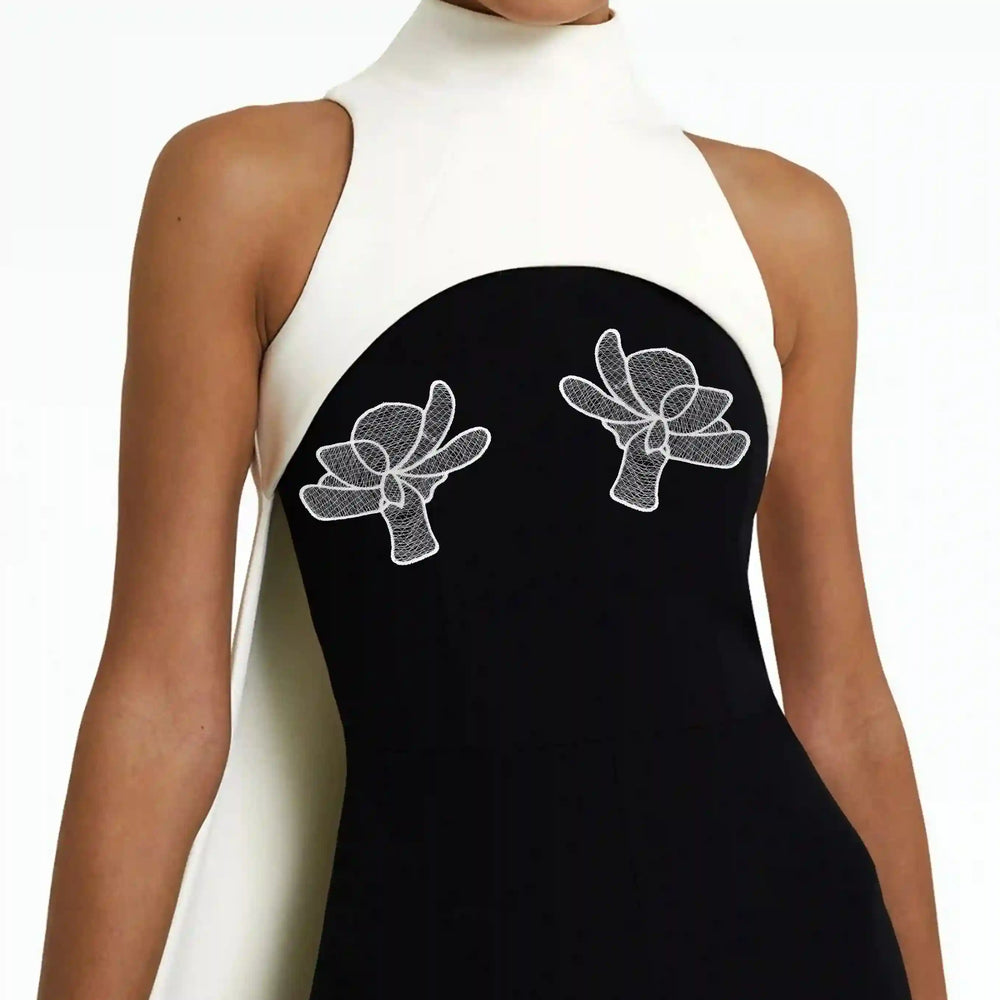 ANI Accessories white lily flower patches stitched as a pair on the front of a black dress 