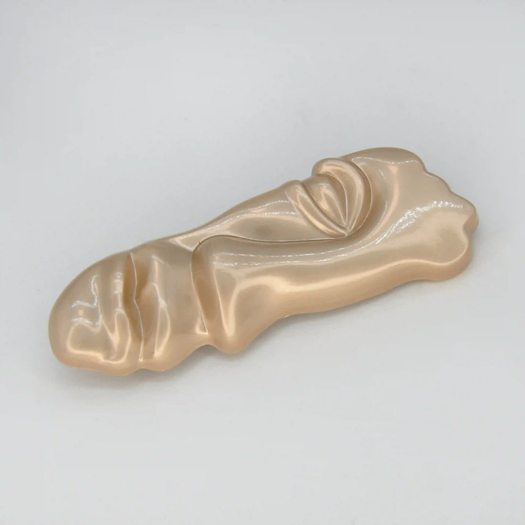 ANI Accessories matte gold abstract brooch lying flat to show its sculpted profile 