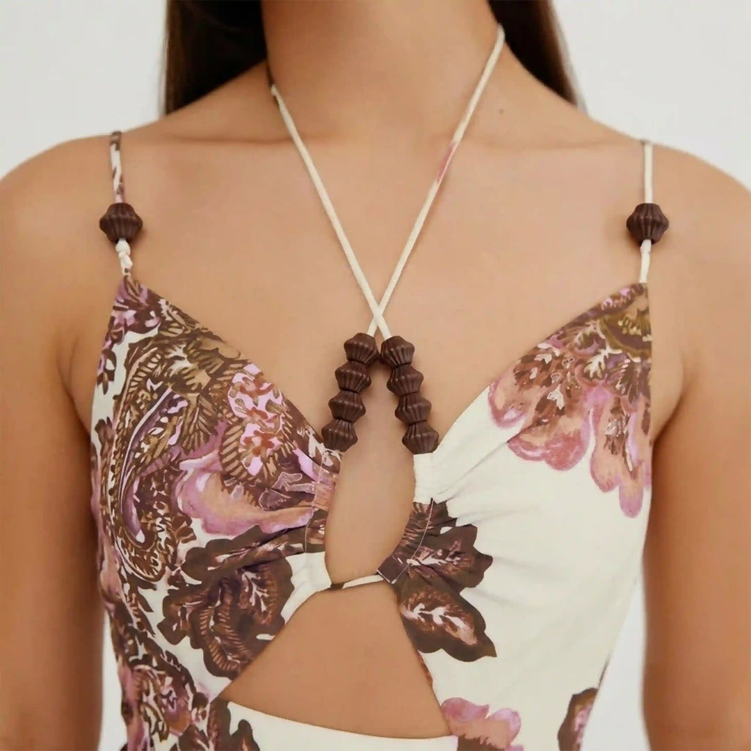 ANI Accessories mini dark brown fluted cord end beads strung on the halter ties and straps of a cream paisley print cut-out top White Background