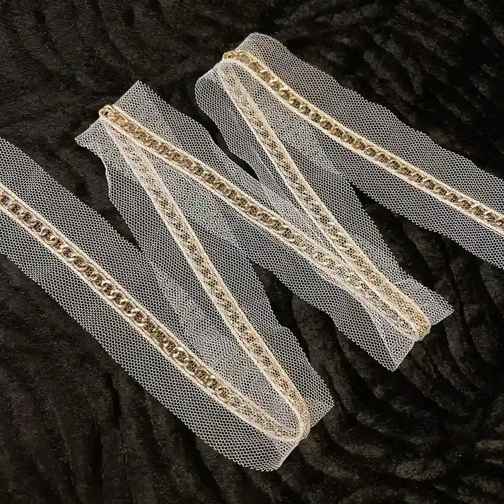 ANI Accessories sheer net lace with gold chain folded in a zigzag with black background 