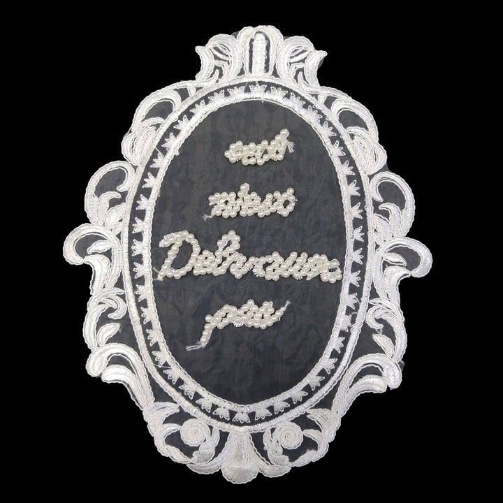 ANI Accessories white oval frame embroidered patch with pearl-beaded lettering, on black background 