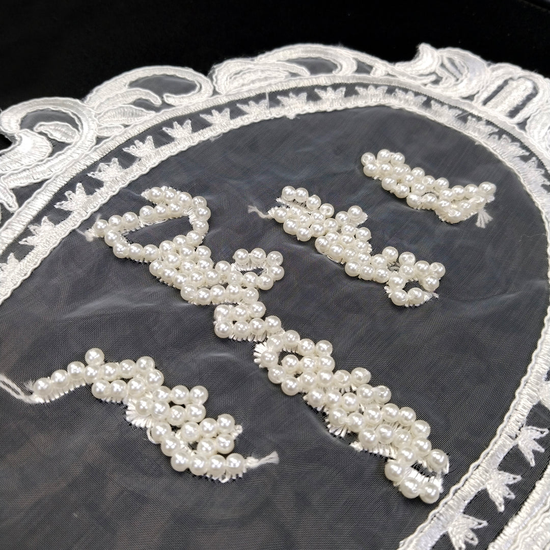 ANI Accessories close-up of pearl bead lettering on sheer net inside an embroidered oval frame 