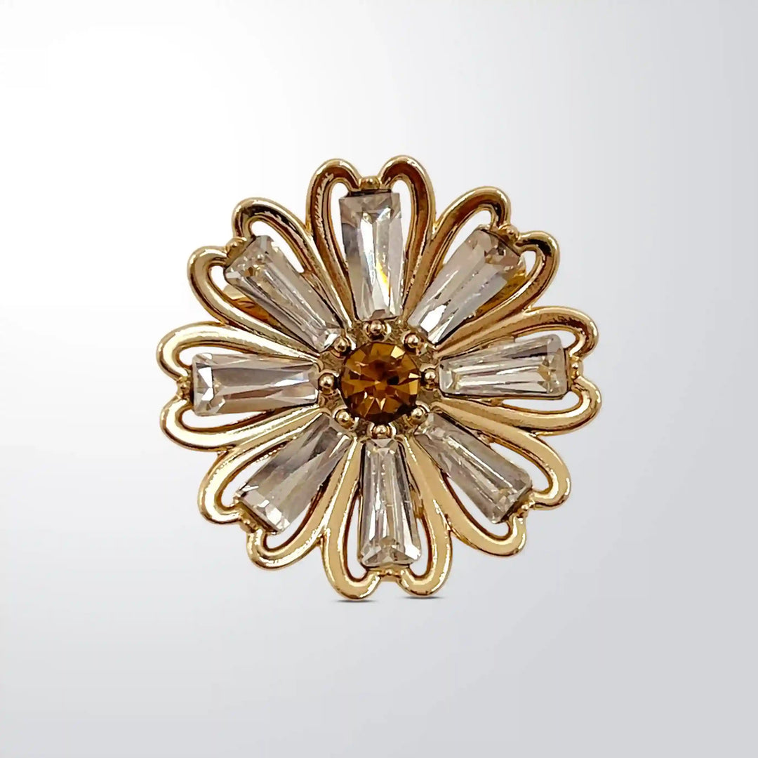 ANI Accessories rhinestone floral brooch pin, gold daisy with clear baguette crystals and amber centre with white color background 
