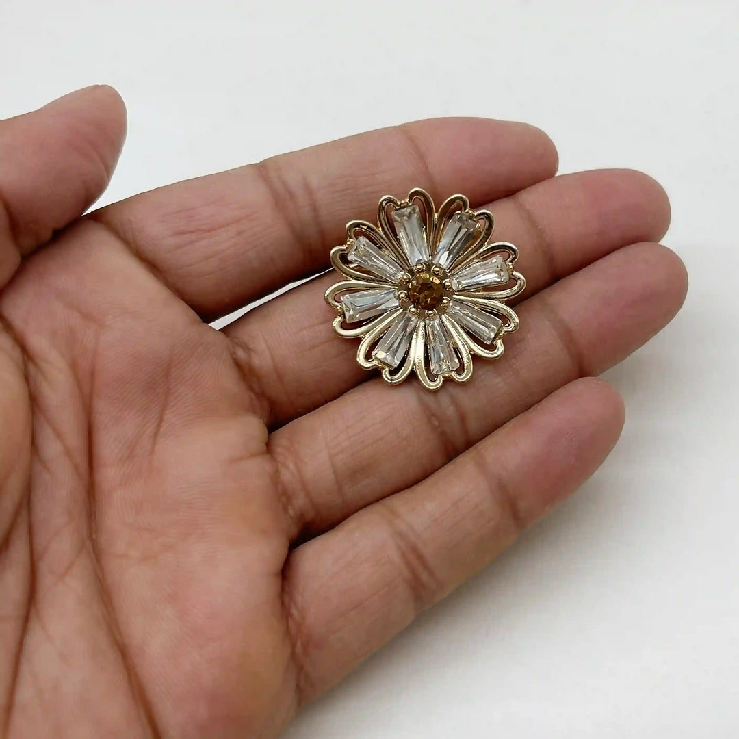 ANI Accessories small rhinestone flower brooch held in hand to show its size 