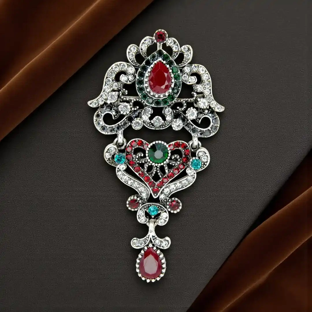 ANI Accessories royal heirloom crystal brooch in antique silver with ruby-red and green stones 