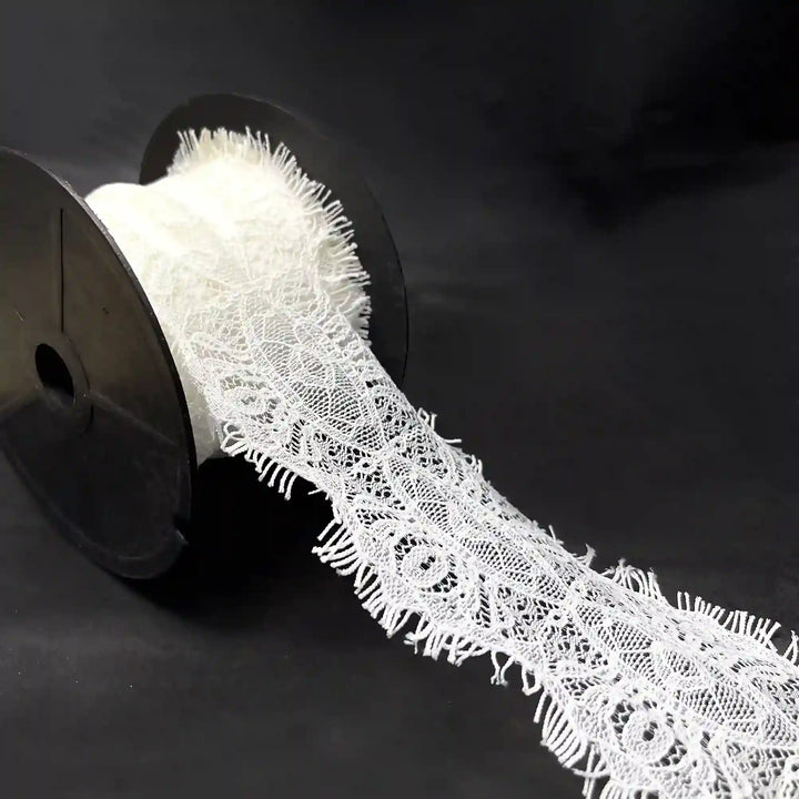 A roll of Scalloped Edge Eyelash Lace in white, perfect for crafting and decoration projects.