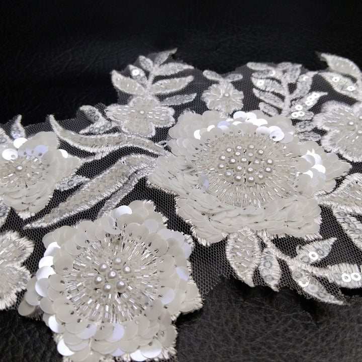 ANI Accessories close-up of clear sequins and beaded flower centres on a white embroidery patch 