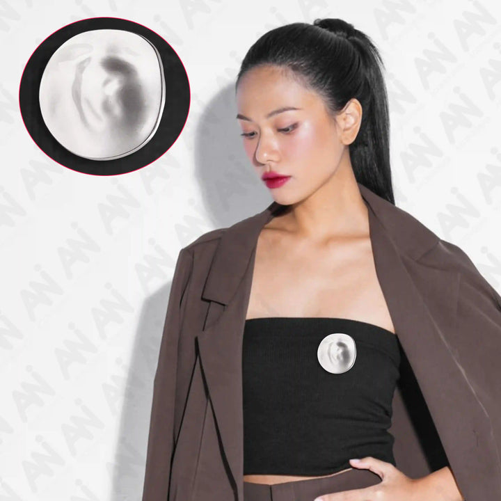 ANI Accessories silver moon brooch pinned on a black bandeau top under a brown blazer 