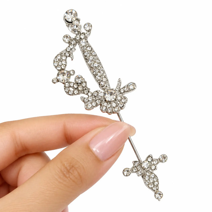 ANI Accessories silver rhinestone sword brooch pin held in hand with white color background 