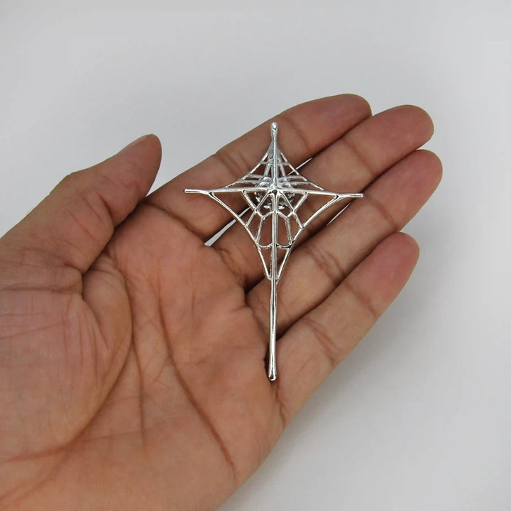 ANI Accessories silver spider web brooch held in hand to show its size 