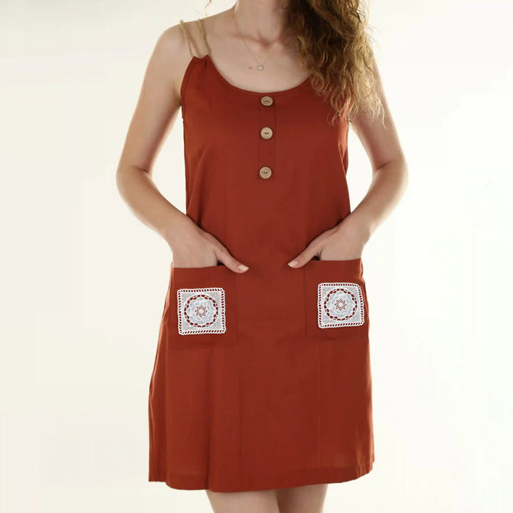 ANI Accessories white square patches stitched on the two front pockets of a rust dress 