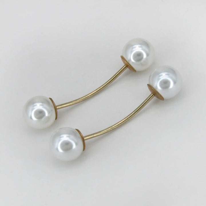Two twin pearl pin brooches with curved gold bars and white pearls with white color background 