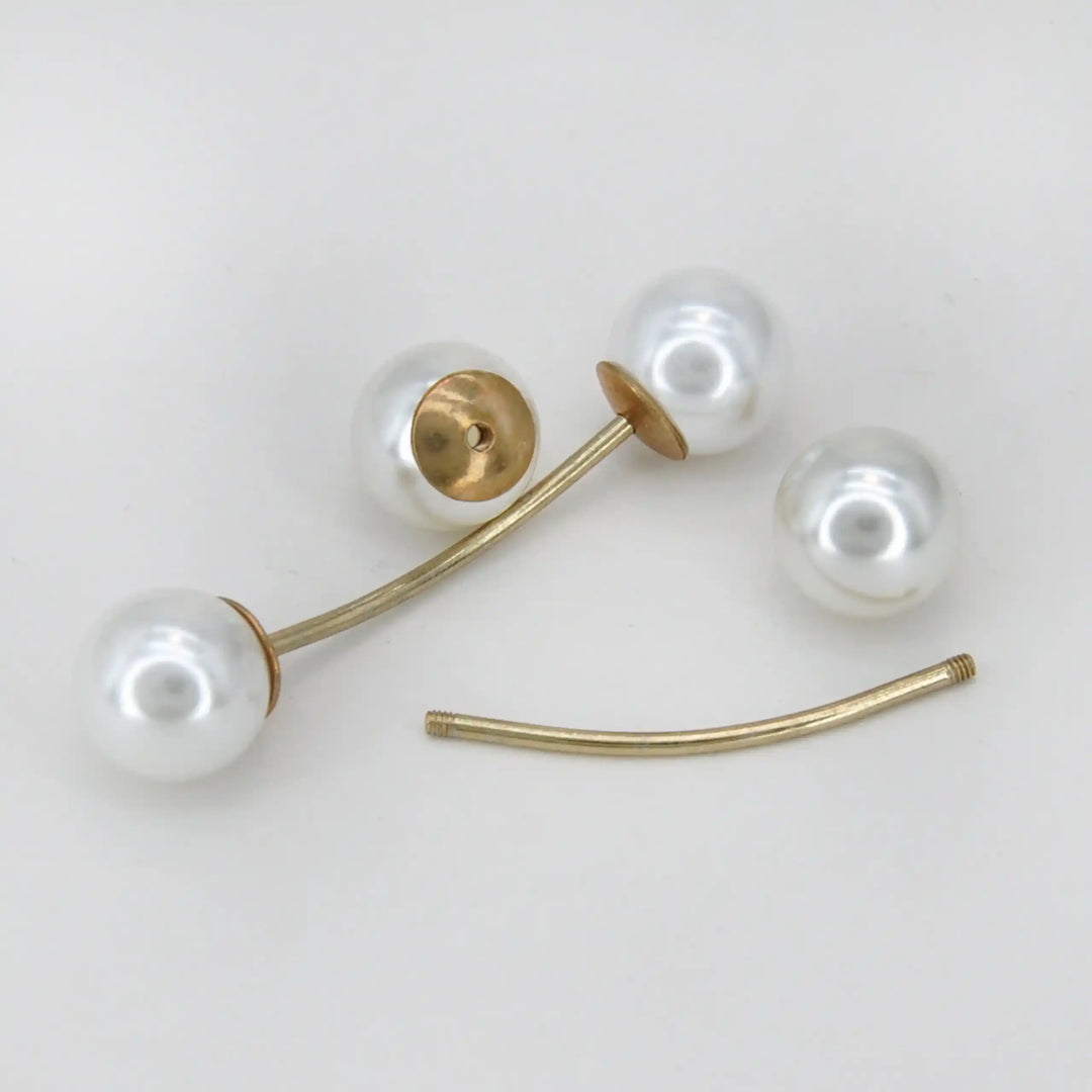 Twin pearl pin shown open with one pearl removed from the gold bar with white color background 