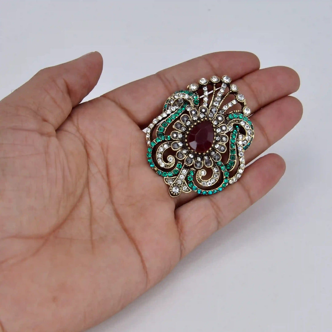 ANI Accessories Victorian style rhinestone brooch held in hand to show its size 