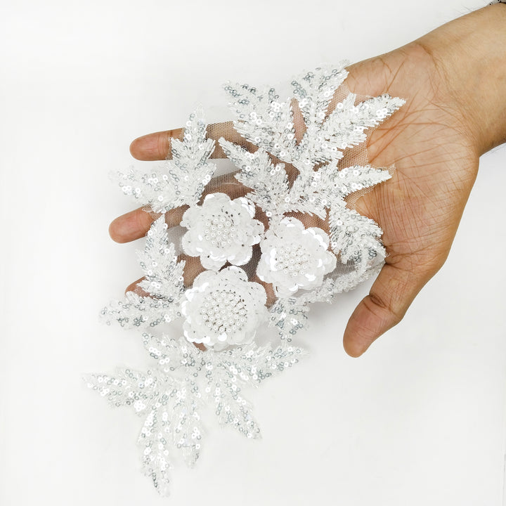 ANI Accessories white beaded flower patch held in a hand to show its size 