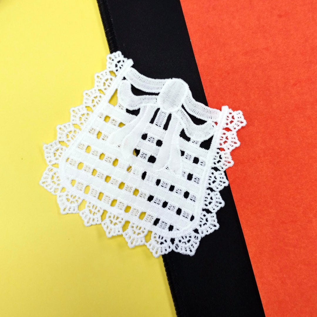 ANI Accessories white bow applique patch laid at an angle on a yellow, black and orange background 
