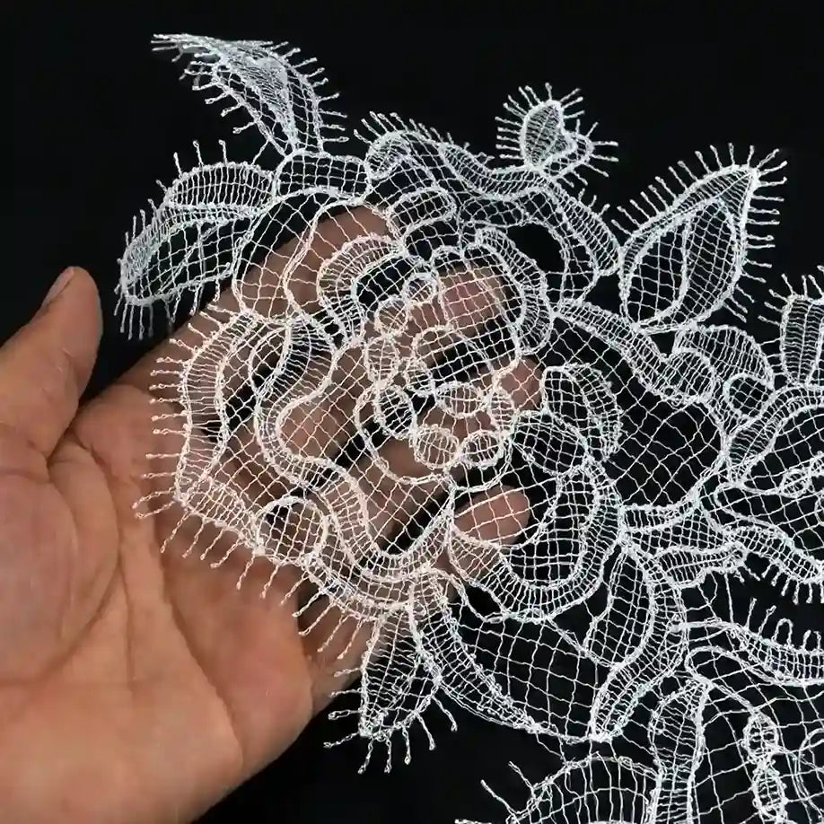 ANI Accessories white eyelash edge patch held over a hand to show its fine thread work 