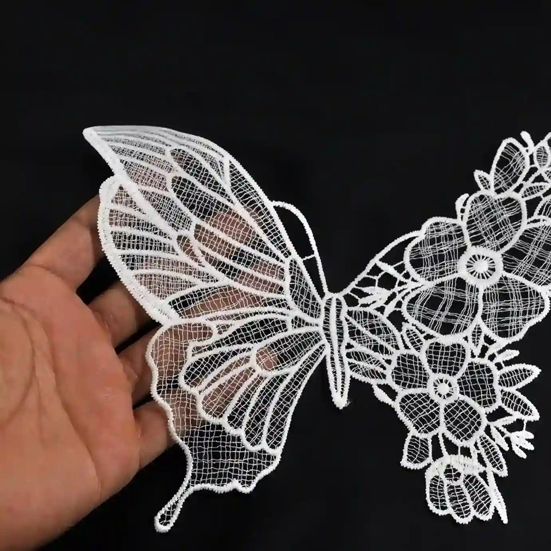 ANI Accessories white floral butterfly patch held in a hand to show its size 
