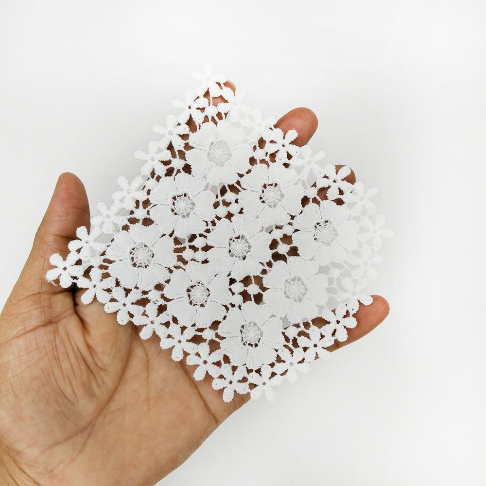 ANI Accessories white floral patch held in an open palm to show its size 
