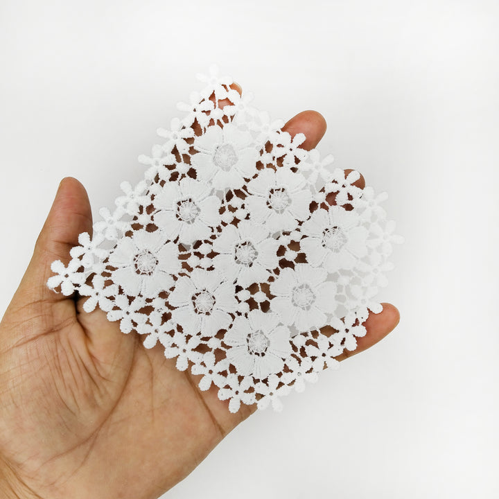 ANI Accessories white floral patch held in an open palm to show its size 