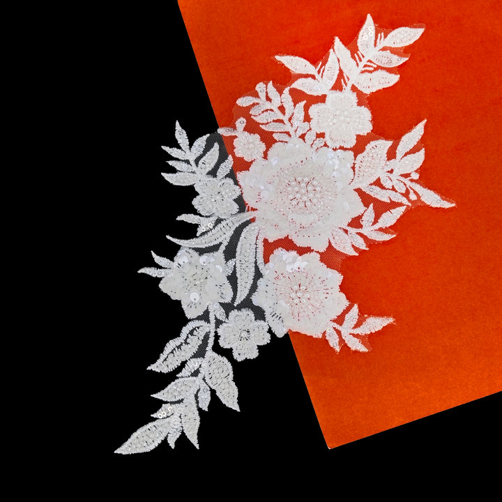 ANI Accessories white flower applique patch on sheer net, on a black and orange background 
