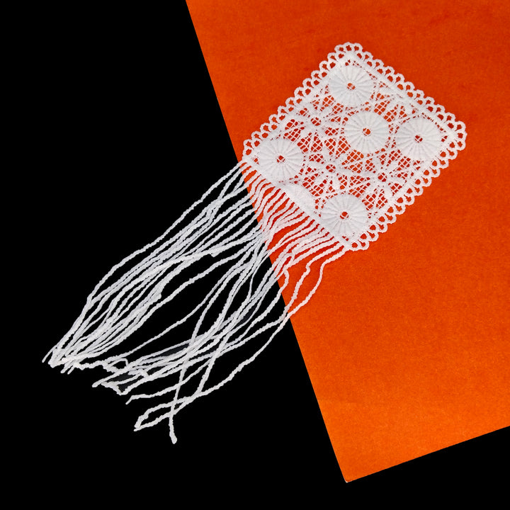 ANI Accessories white flower patch for decoration with loose fringe on a black and orange background 