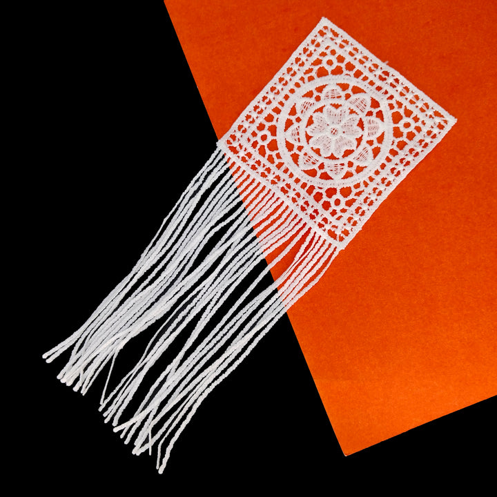 ANI Accessories white flower patch with straight fringe laid at an angle on black and orange 