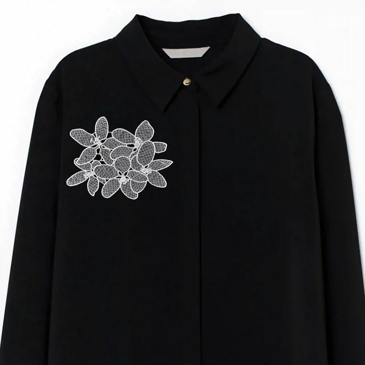 ANI Accessories white flowers patch stitched on the chest of a black shirt 