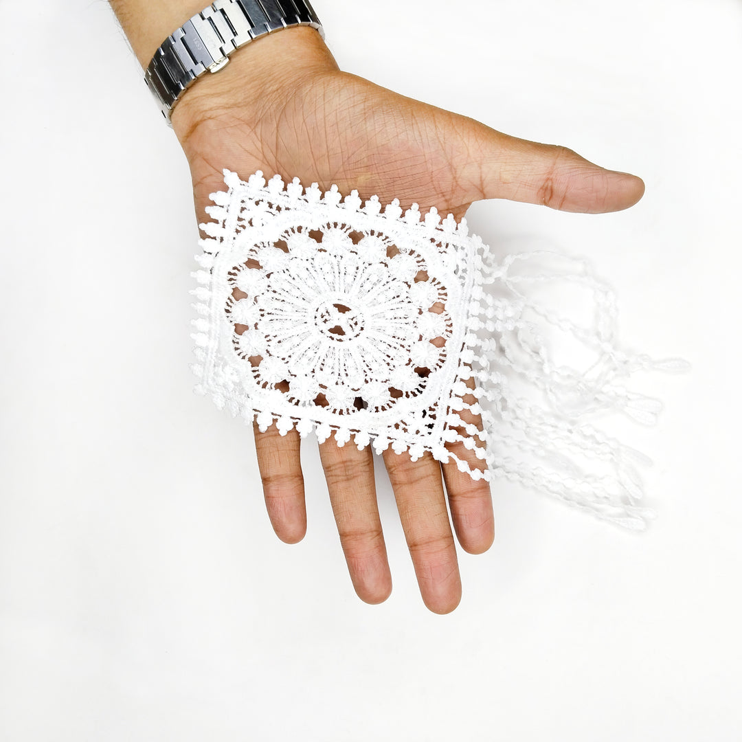 ANI Accessories white medallion patch with hanging strands draped over a hand to show its size with white color background 