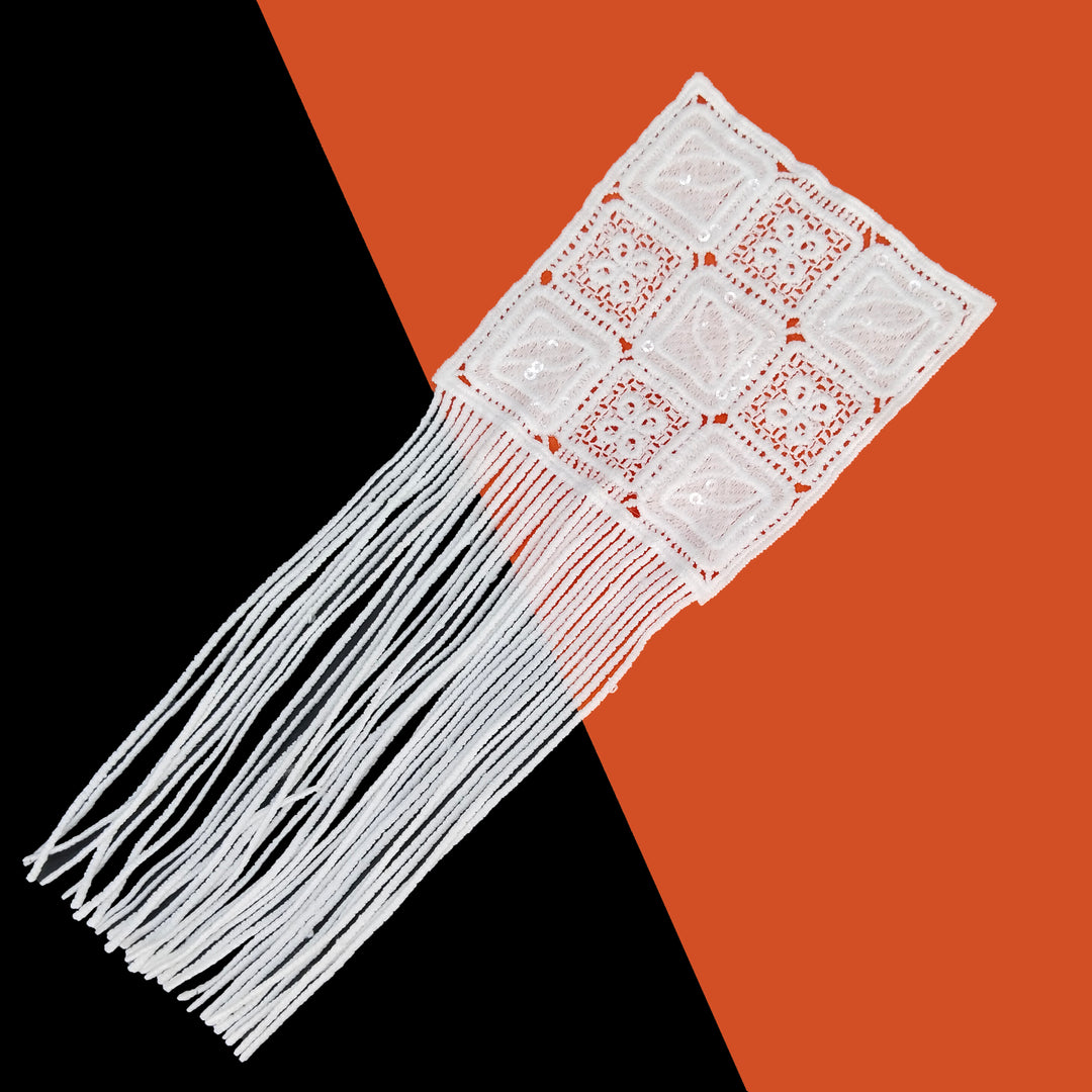 ANI Accessories white patch with fringe laid at an angle on a black and orange background 