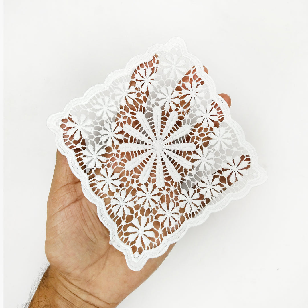 ANI Accessories white starburst flower patch held in an open palm to show its size 