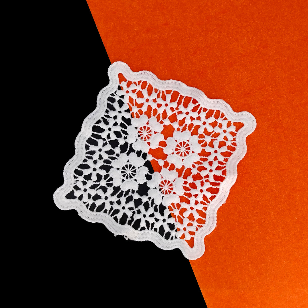 Dyeable white spun poly flower patch with wavy border, angled view 