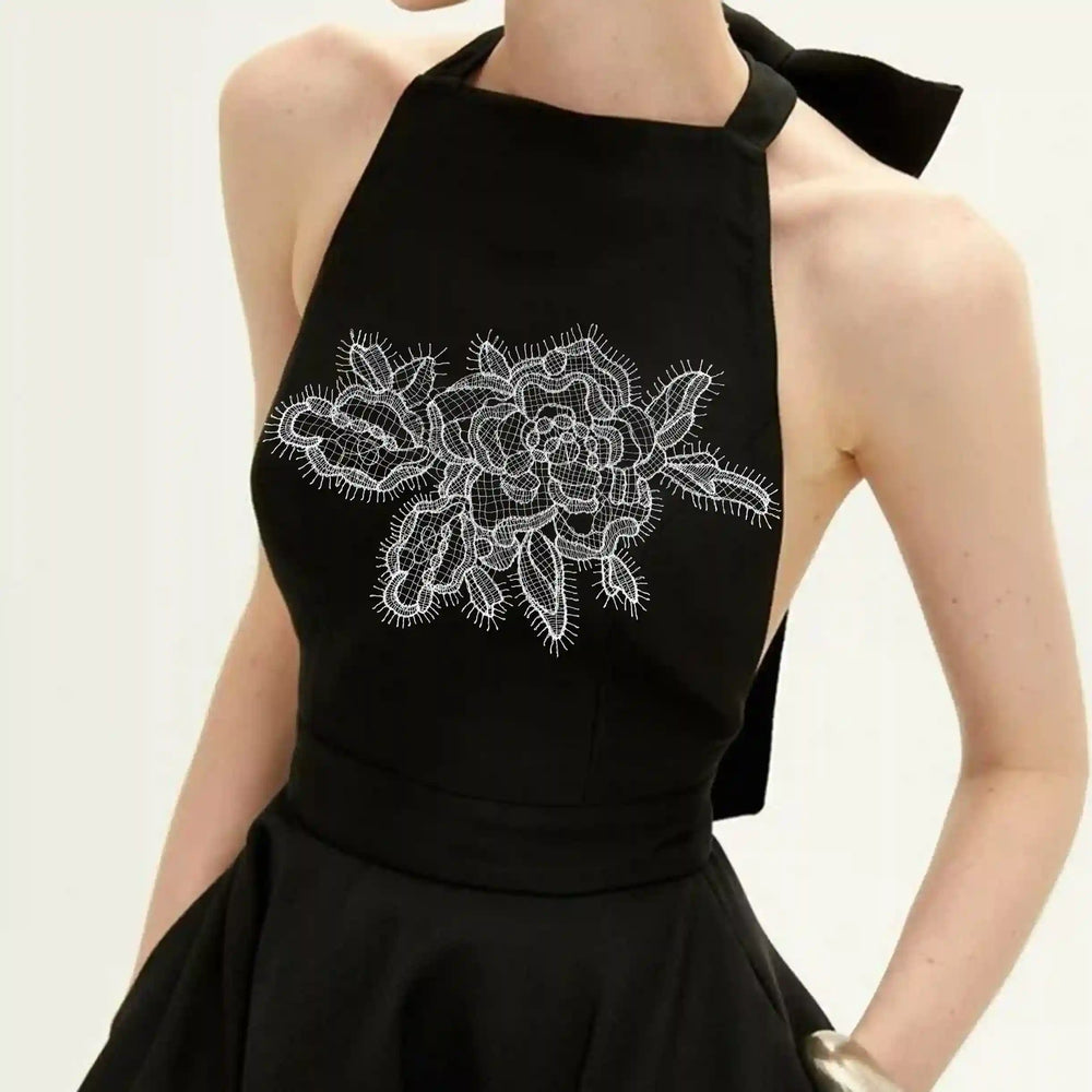 ANI Accessories wide white flower patch stitched across the front of a black halter top with white color background 